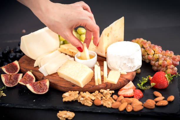 istock different kinds of cheeses, honey, figs, nuts, grapes, and fruit on a table. Selective focus. Copy space 877184306