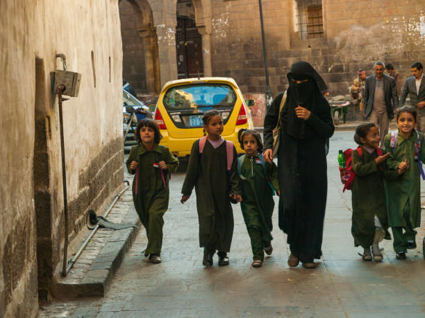 donna in abito nero con bambini piccoli - yemen foto e immagini stock