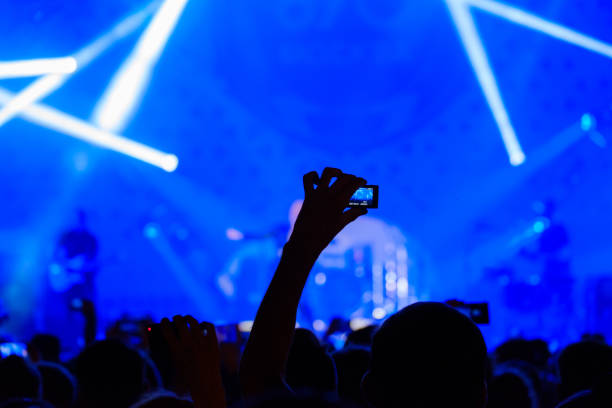 istock Concert visitor shoots video 877184464