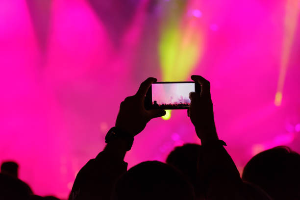 istock Concert visitor shoots video 877184558