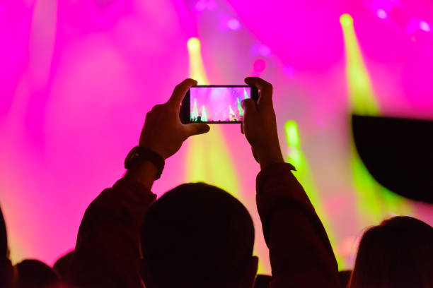 istock Concert visitor shoots video 877187610
