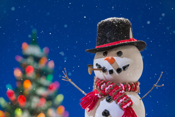 istock Snowman with a lit Christmas tree while snowing - Close-up 877187632