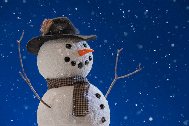istock Snowman wearing a fedora hat while snowing - close-up 877187684