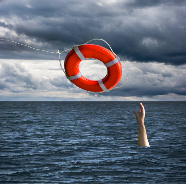 life saver rescuing a drowning person in the sea - save oceans imagens e fotografias de stock