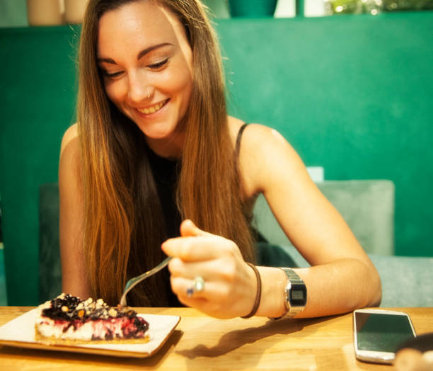 istock Young woman enjoying her cheesecake. 877193368