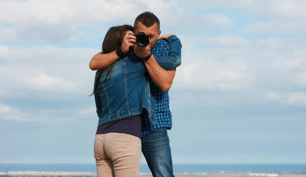 istock Beautiful young couple hugging, holding camera 877198368