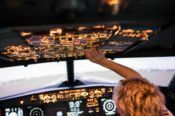 trainee pilot operating various switches in flight simulator cockpit - airplane cockpit taking off pilot imagens e fotografias de stock