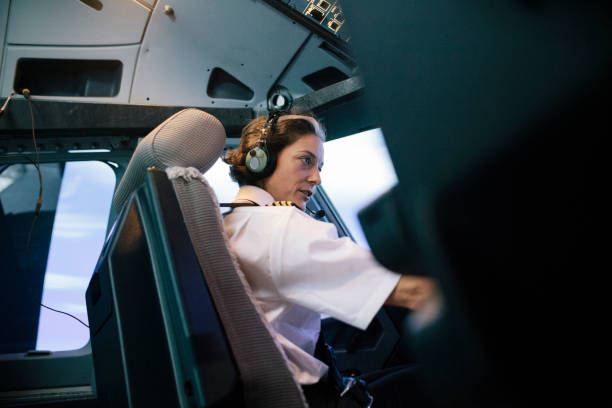 Flight Instructor Sitting In Simulator Cockpit Operating Aircraft stock photo