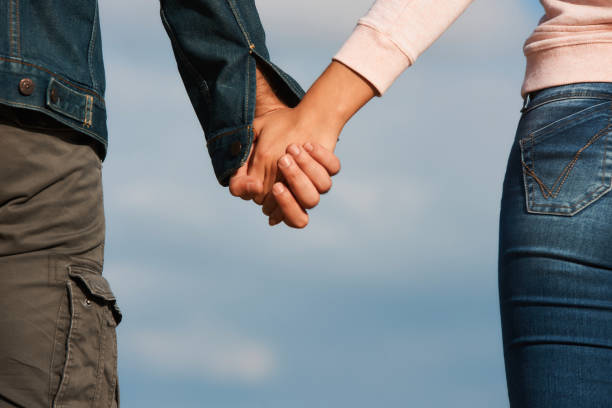 istock Couple holding hands over blue sky background 877201212