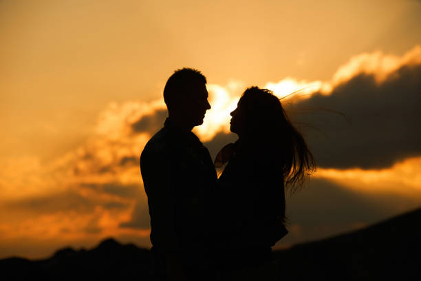 istock Kissing couple silhouette in the sunset sky 877201414
