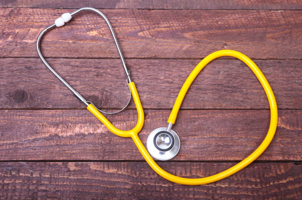 istock Medical stethoscope and tablets isolated on wooden background 877202792
