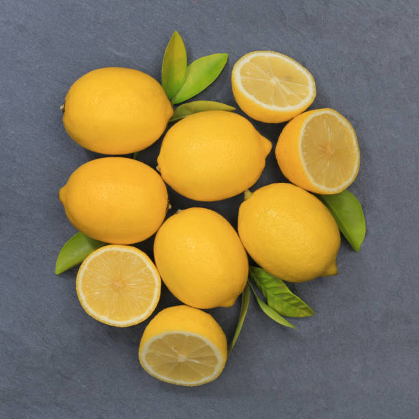 istock Lemon lemons fruits square slate top view 877202894