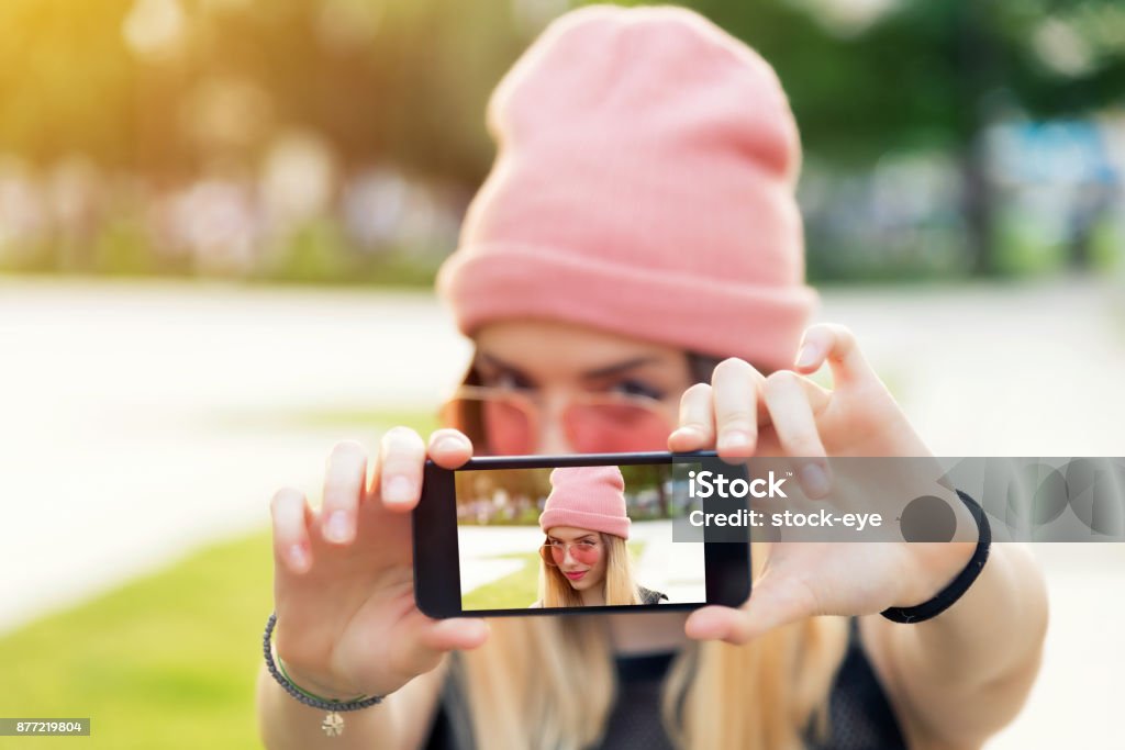 Beautiful woman makes self portrait on smartphone view of screen Human Face Stock Photo