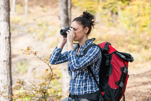 istock Young hiker woman taking photo with old camera 877219850