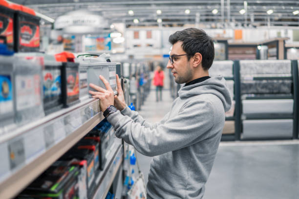 smart male customer buying car battery n the car supermarket smart male customer buying car battery n the car supermarket. Difficult decision which battery to buy car battery stock pictures, royalty-free photos & images