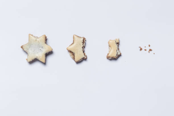 nibbled off cinnamon stars on white background as symbol of the advent season - cookie christmas shortbread food imagens e fotografias de stock