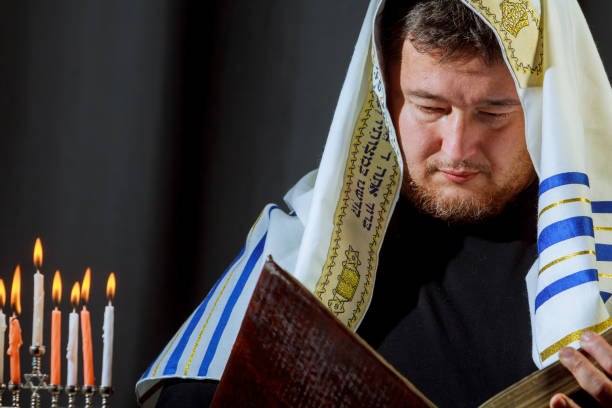 istock male hand lighting candles in menorah on table Hanukkah 877243974