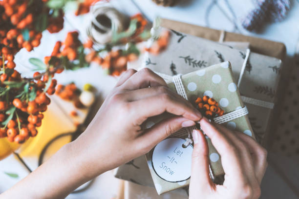 istock Woman hands gift wrapping Christmas presents, let it snow 877246912