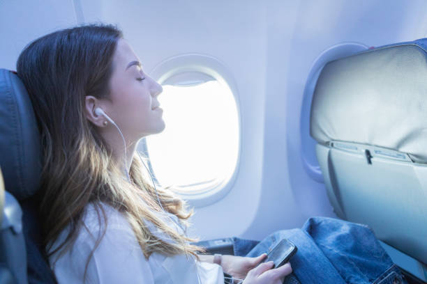 young woman rests with music during air travel - air vehicle audio imagens e fotografias de stock