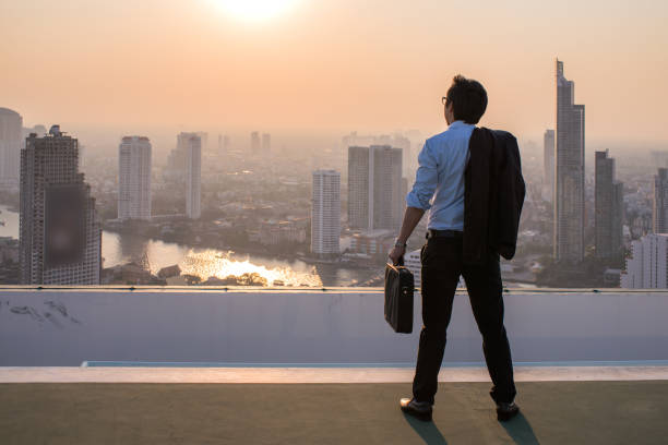 istock Businessman is looking at city on rooftop 877257050