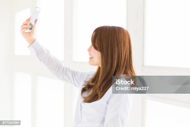 Mujer A Un Teléfono Inteligente Foto de stock y más banco de imágenes de Teléfono inteligente - Teléfono inteligente, Sólo mujeres, 20 a 29 años