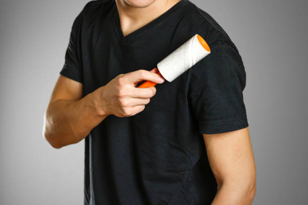istock Guy brushing his black t-shirt from debris sticky roller 877260338