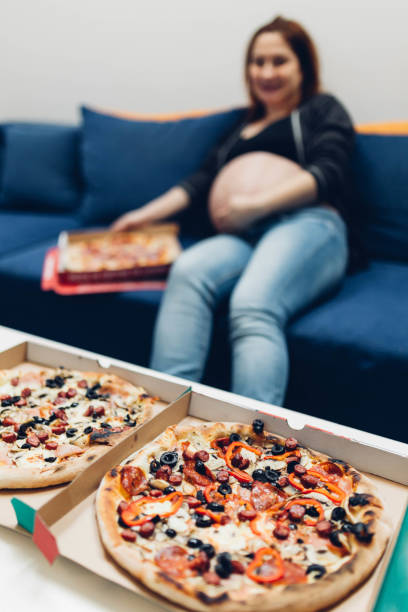 istock Pregnant woman eating pizza 877261506