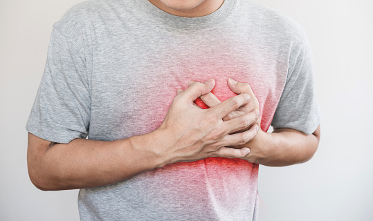 un hombre tocando su corazón, con rojo resalte de ataque cardíaco, insuficiencia cardíaca y otras enfermedades del corazón photo