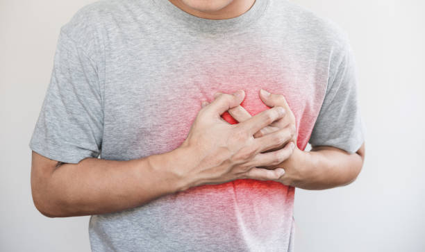 a man touching his heart, with red highlight of heart attack, heart failure and others heart disease stock photo