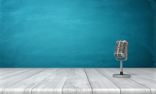 3d rendering of a single metal retro microphone placed on its short stand over a wooden desk. Performance arts. Singing and broadcasting. Podcast business.