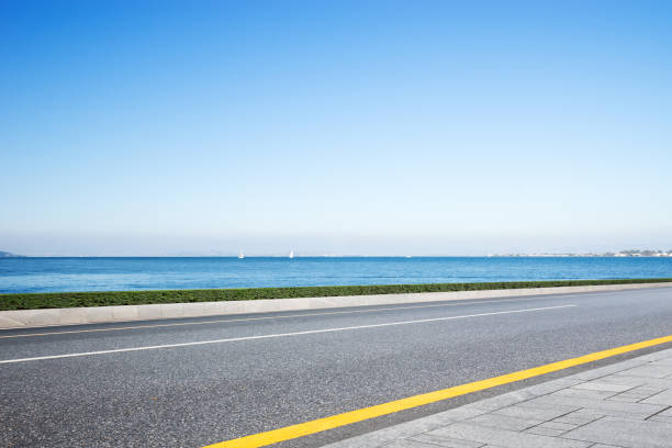 istock empty asphalt road with blue sea in blue sky 877269666