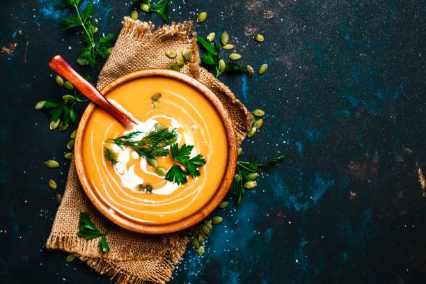 zuppa di zucca cremosa in una ciotola di legno - food healthy eating carrot table foto e immagini stock