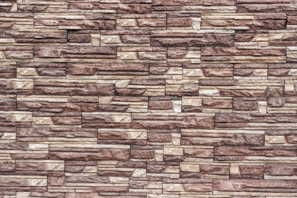 istock Decorative brown wall of artificial torn stone as a background or texture. 877274398