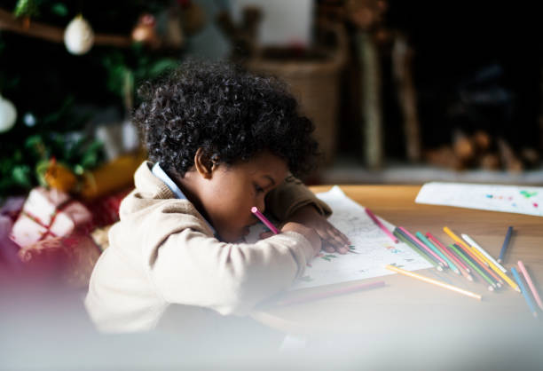 istock African kid enjoying a coloring book 877277578