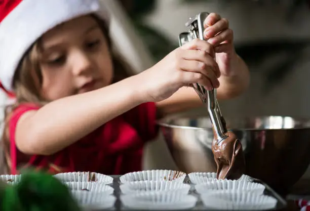 Photo of Little girl making chocolate cupcakes