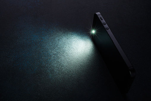 Lantern smartphone shines on a dark background.