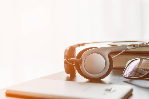 istock Headphones with book and mobile phone on wood table 877290128