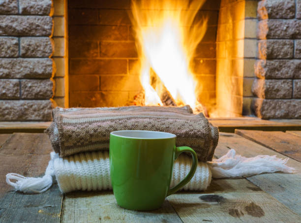 istock A cup of  tea,  wool things near cozy fireplace. 877294670