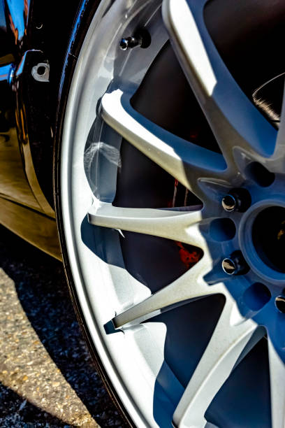 istock White rims on a black car with red breaks peeking out from the shadows 877301088