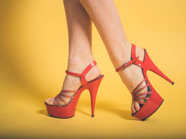 istock Woman in red high heels on yellow 877301650