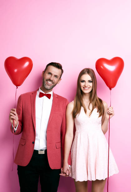 istock Affectionate couple with heart shape balloons holding hands 877307752