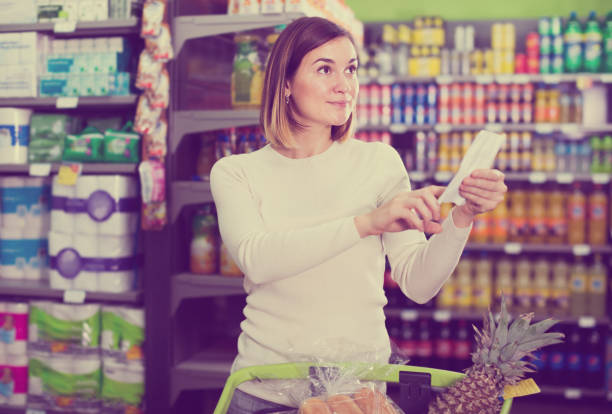 istock female customer looking at notes in shopping list 877308654