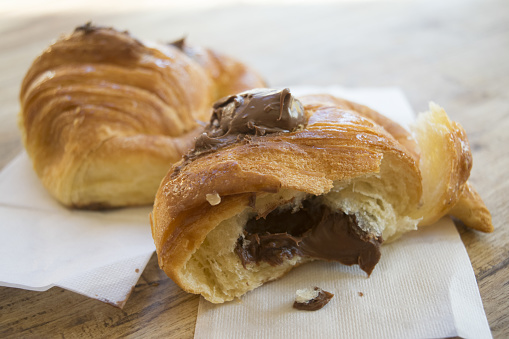 chocolate croissant half cut stuffed with melted chocolate