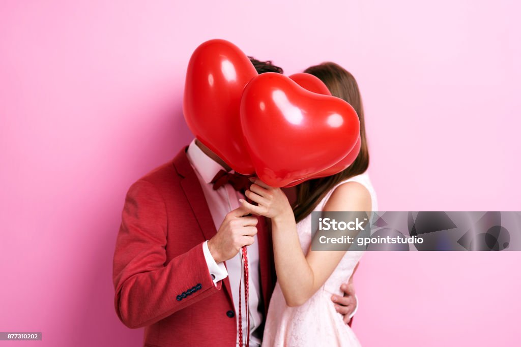 Couple Embrasser derrière ballons - Photo de Saint Valentin libre de droits