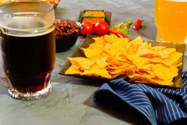 istock Nachos  with Tortilla chips tomato salsa, bean and mustard and two glass with beer on rustic stone background. A texture background.Copy paste place 877320072
