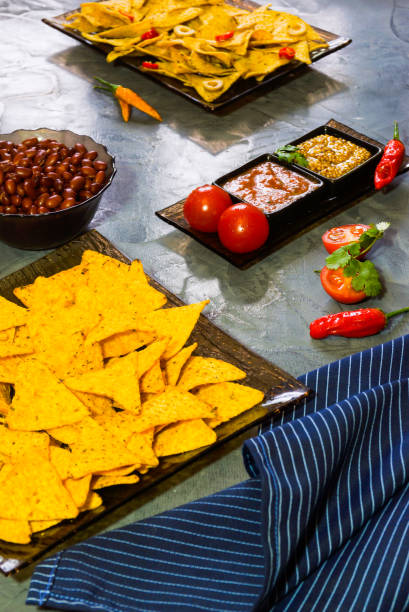 istock Nachos  with Tortilla chips tomato salsa, bean and mustard on rustic stone background.A textured background.Copy paste place 877320452