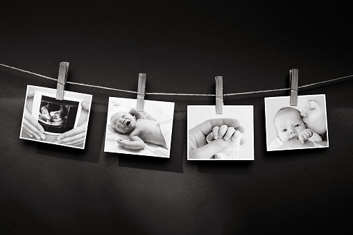 Collage of black and white photos story of a newborn and mother hanging on the clothesline on a textured wall background. Family, Childbirth, New Life concept background.