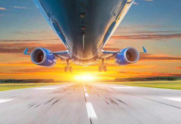 istock Passenger airplane landing at sunset on a runway. 877324194