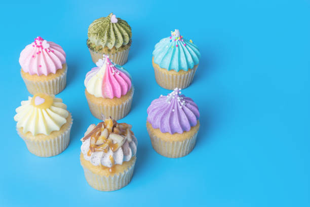 istock Colorful mini cupcake on blue background copy space 877324660
