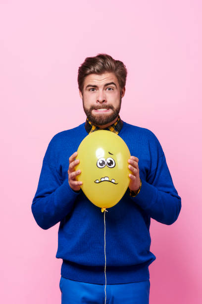 Angry man trying to squeeze a balloon